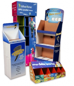 A selection of promotional cardboard display stands with various advertisements. One stand promotes a ‘Tornado Power’ product with a blue and white design, another features a GPS locator phone from "Whereifone,” while the third stand, resembling a shipping container, promotes a massage hook.