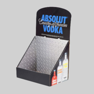 A countertop display stand for Absolut Vodka, featuring a metallic diamond-plate design with "ABSOLUT Country of Sweden VODKA" written on the top panel. Sharp graphics on the lower front section showcase images of different Absolut Vodka bottle varieties.