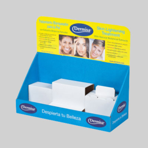 A blue product display stand with Dermisa branding features sharp graphics of four smiling individuals and text in both Spanish and English promoting a skin lightening treatment with natural botanical extracts. The stand includes compartments with white boxes, ready for easy package inclusion or direct placement in a shipping box.