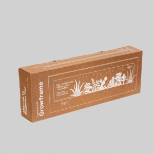 A rectangular brown cardboard box labeled "Growframe" with sharp graphics of various plants and text reading "Full Spectrum Grow Light Planter." The package is displayed against a plain gray background.