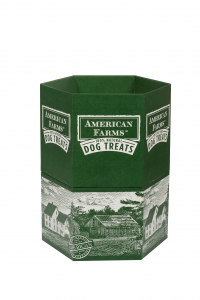 A green, hexagonal box with "American Farms 100% Natural Dog Treats" written on it. The packaging features sharp graphics of white illustrations depicting farmhouses and fields.