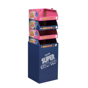 Side view of a tall supermarket display stand for "Champs Super Glow Pop." The stand has four empty shelves, each with a pink and blue design featuring a cartoon character on the top. The base, resembling a shipping container, is solid blue with the product's logo in white text.