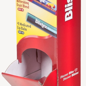 A close-up of a red cardboard display container for Blistex products, housing a refreshing fruit blend and medicated lip balm with SPF 15. The front and side of the packaging display "Blistex" branding, and the slogan "Discover Bliss, Discover Blistex" appears at the bottom.