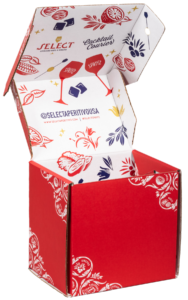 An open, vibrant red subscription box with decorative prints. The box's inside and flaps are adorned with cocktail-themed illustrations and text, including social media handles, a logo, and artistic drawings of glasses, lemons, and other cocktail ingredients.